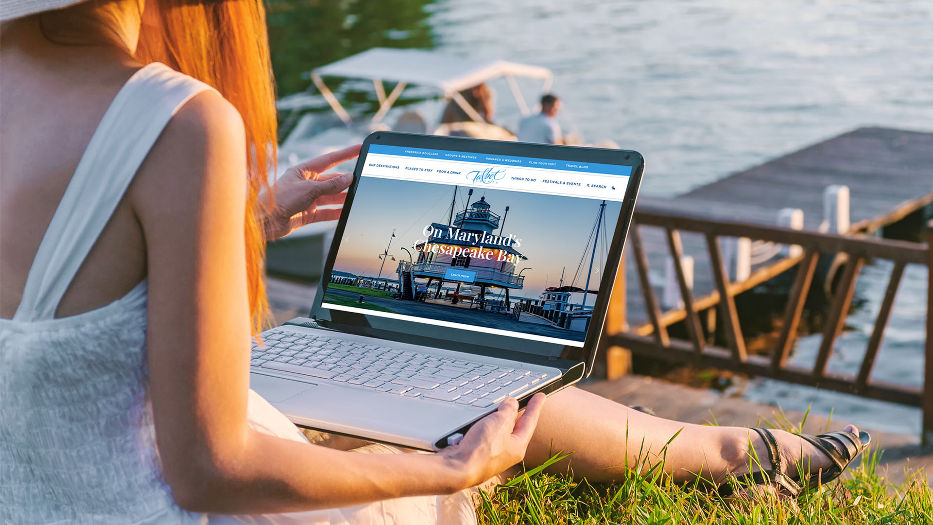 The Talbot County tourism web design being browsed waterside by a local woman on a laptop